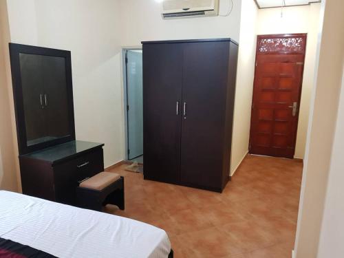 a bedroom with a bed and a cabinet and a door at Ran-Weera Villa in Kahawa