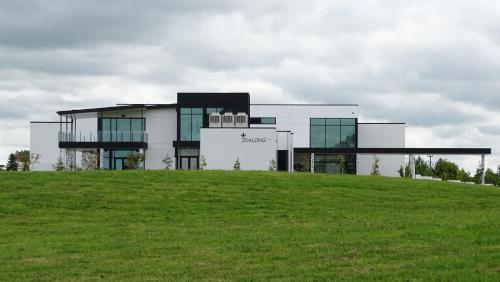 a large building on top of a grassy hill at Argent Motor Lodge in Hamilton