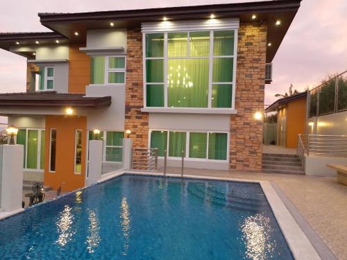 a swimming pool in front of a house at Lee Boutique Hotel Tagaytay in Tagaytay