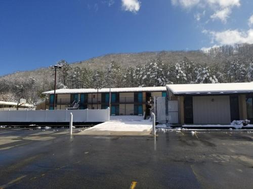 a parking lot in front of a building with a mountain at Blue Sky Inn- Complimentary Happy Hour Th-Sun, Veteran owned, Full Breakfast, Best green space, 1 mile from Blue Ridge, Fire Pit in Blue Ridge
