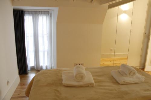 a bedroom with two towels on a bed with a mirror at Augusta Street 213 - 4 Dto in Lisbon