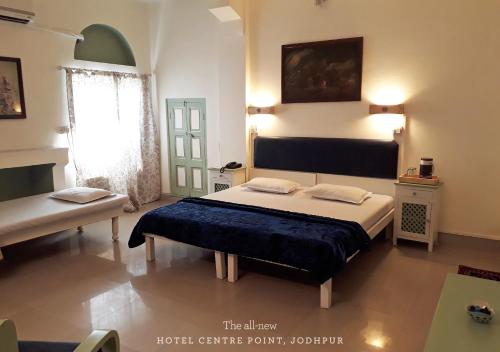 a bedroom with a large bed and a window at Hotel Centre Point in Jodhpur