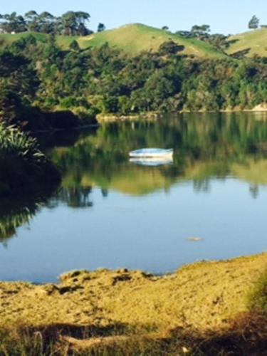 a boat sitting in the middle of a lake at Admiral Waters in Cooks Beach