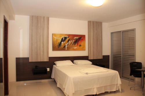 ein Schlafzimmer mit einem Bett und einem Wandgemälde in der Unterkunft Executivo Hotel in Montes Claros