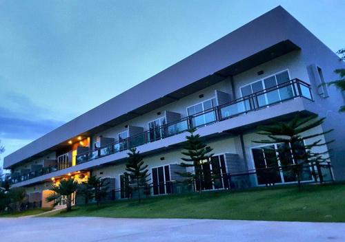 a large white building with balconies on the side of it at Hadthong Resort in Pak Phayun