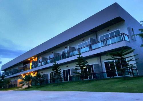 een groot wit gebouw met balkons aan de zijkant bij Hadthong Resort in Pak Phayun