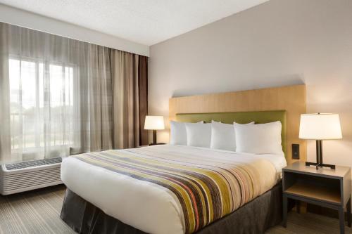 a hotel room with a large bed and a window at Country Inn & Suites by Radisson, Austin North Pflugerville , TX in Round Rock