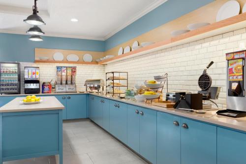 a large kitchen with blue cabinets and white walls at Country Inn & Suites by Radisson, Austin North Pflugerville , TX in Round Rock