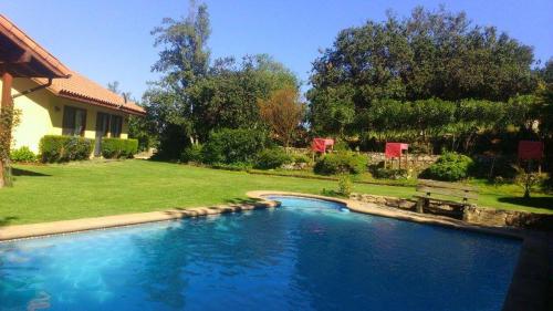 a swimming pool in a yard next to a house at Parcela privada con piscina en Olmué in Olmué