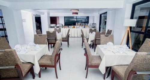 a dining room with white tables and chairs at Golden Sunrise Machupicchu in Machu Picchu