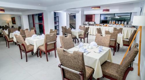 a dining room with white tables and chairs at Golden Sunrise Machupicchu in Machu Picchu