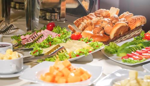 a buffet with plates of food on a table at Golden Sunrise Machupicchu in Machu Picchu