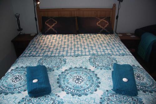 a bedroom with a bed with blue pillows on it at Bower's Hideout in Kandos