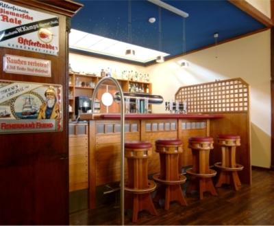 a bar in a restaurant with a row of stools at Restaurant & Hotel Wismar in Wismar