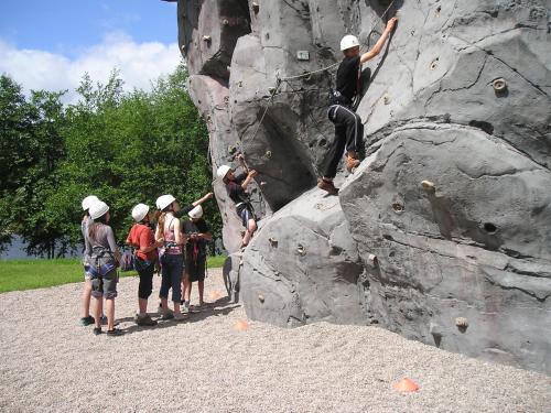 a group of people climbing a rock wall at Camping Base de Loisirs du Lac de la Moselotte in Saulxures-sur-Moselotte