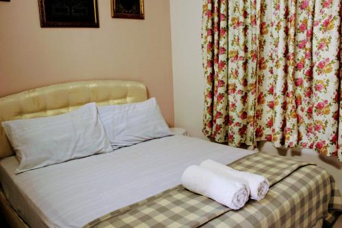 a bed with two towels sitting on top of it at Bayan Homestay in Bayan Lepas