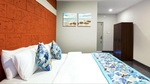 a bedroom with a bed with blue and white pillows at Blue Ocean Sands - On the Beach in Kumta