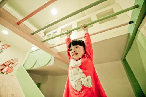 安平的住宿－吾宅溜滑梯親子民宿 ，挂在梯子上的一条红毯上的小孩