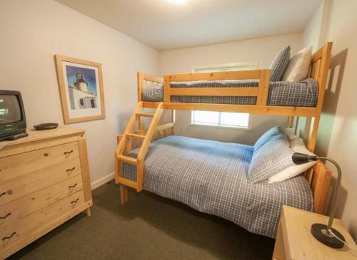 a bedroom with two bunk beds and a desk at Luxury 2BR Oceanfront Condo by OnlyBC 201 in Tofino