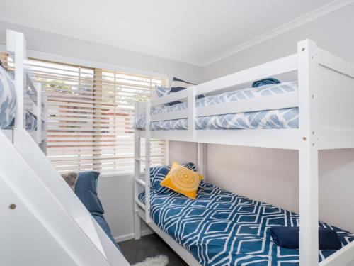 モリーモックにあるFairway Haven Getawayのベッドルーム1室(二段ベッド2台、窓付)が備わります。