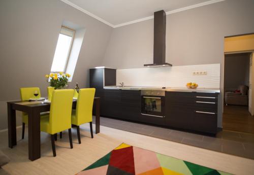 kuchnia ze stołem i żółtymi krzesłami w obiekcie deákvilla37 apartman Eger w Egerze