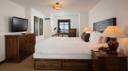 a bedroom with a large white bed and a television at Madeline Hotel and Residences, Auberge Resorts Collection in Telluride