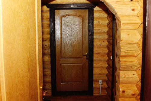 una puerta de madera en una habitación con una pared de madera en Sadyba Kazkove Dzherelo, en Verkhovyna