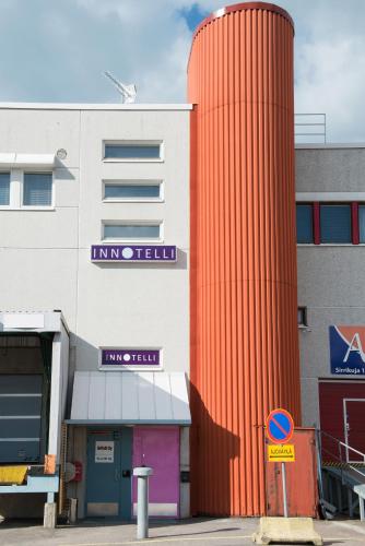 a building with a large orange column next to it at Innotelli Apartments in Helsinki