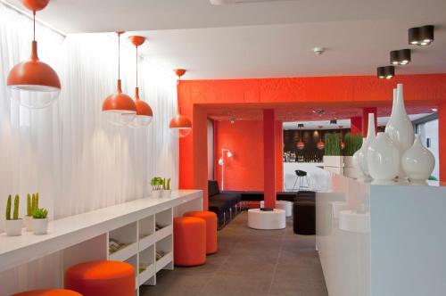 um salão laranja e branco com cadeiras laranja e branca em Hôtel De L'octroi em Carcassonne