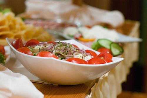 a white bowl of tomatoes on a table at Hotel Świeradów in Świeradów-Zdrój