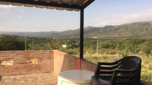a patio with a table and chairs and mountains in the background at Complejo M&M in Bialet Massé