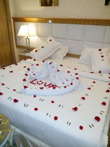 a white bed with red roses on it at Golden dune Hotel Services-Al Fayhaa in Riyadh