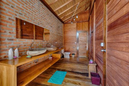 La salle de bains est pourvue de 2 lavabos et d'un mur en briques. dans l'établissement Kuda Laut Boutique Dive Resort, à Bunaken