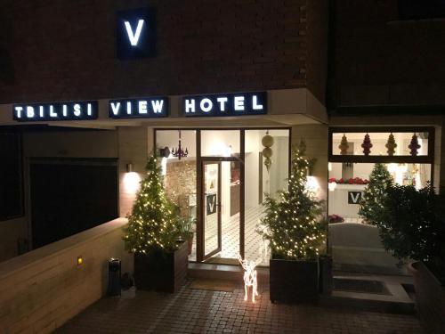 a hotel with christmas trees in front of a building at Tbilisi View Hotel in Tbilisi City