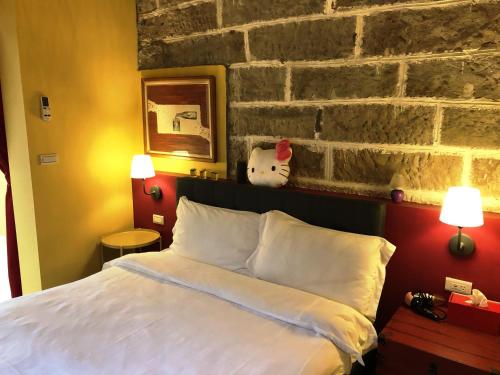 a bed in a room with a brick wall at Dosun B&B in Jiufen