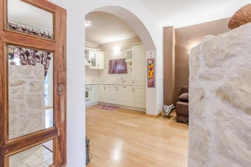 uma porta aberta que leva a uma cozinha com armários brancos em Apartment Jeger em Povljana
