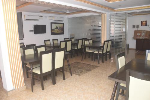 a dining room with tables and chairs and a tv at Athi Resorts in Bogmolo
