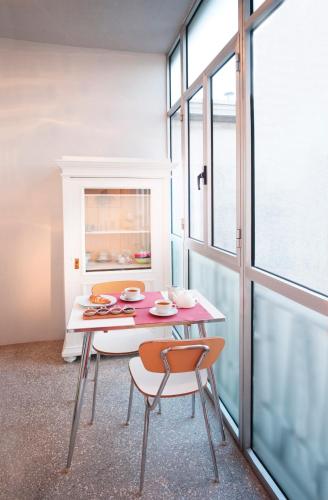 a dining room with a table and two chairs at Boutique Hotel Albero Nascosto in Trieste