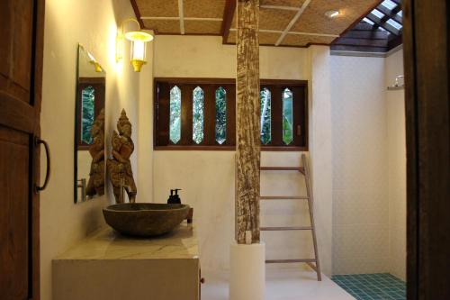 a bathroom with a stone sink and a ladder at baanchandra in Chiang Mai