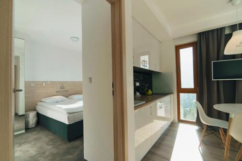 a hotel room with a bed and a table at Apartamenty Willowa in Szczyrk