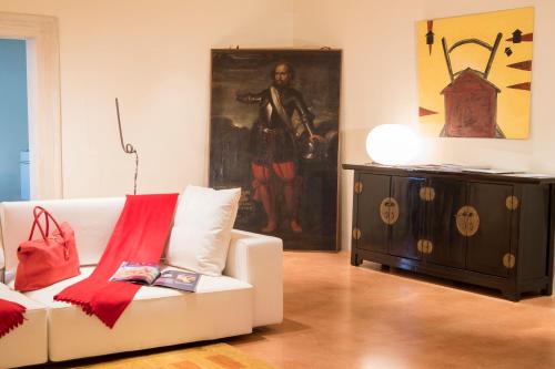 a living room with a white couch and a painting at La Barchessa di Villa Pisani in Lonigo