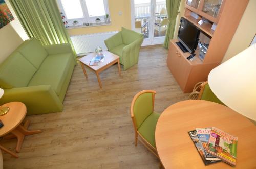 ein Wohnzimmer mit grünen Möbeln und einem Tisch in der Unterkunft Wohnpark Stadt Hamburg - Apt. 15 in Binz