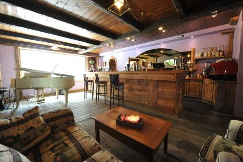 a living room with a piano and a bar at Hotel Bucaneve in Breuil-Cervinia