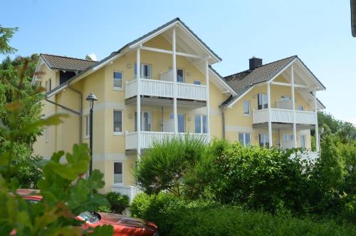 a large yellow apartment building with white balconies at Wohnpark Stadt Hamburg - Apt. 22 in Binz