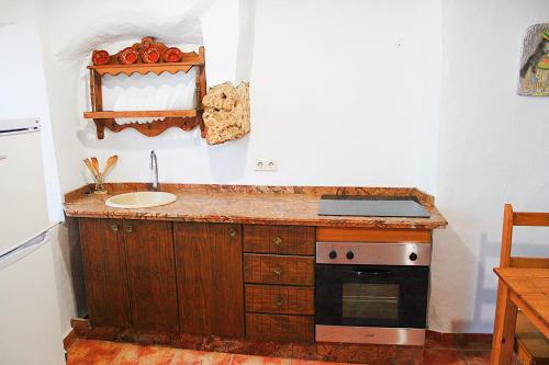 a kitchen with a counter with a sink and a stove at Apartment Frasquita Boa in Júzcar