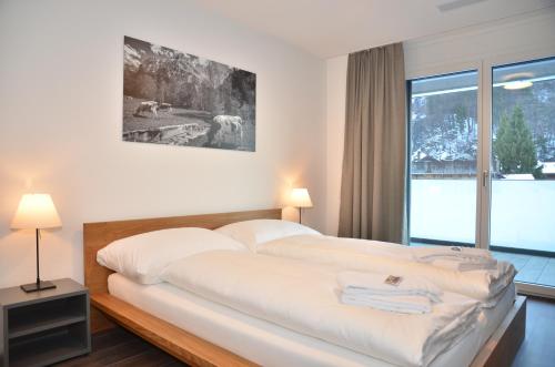 a bedroom with a large bed with a window at Apartment Alperose - GriwaRent AG in Interlaken