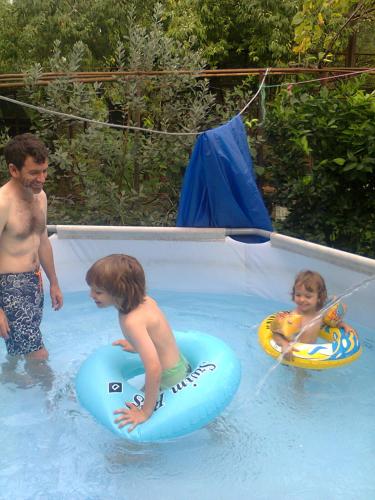 two children on inflatables in a swimming pool at Giorgi's Homestay in Kutaisi