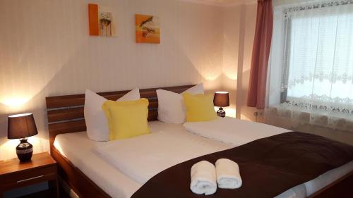 a bedroom with a bed with yellow and white pillows at Hotel Pension Nordlicht in Büsum