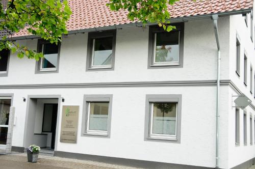 un edificio blanco con ventanas y un cartel en él en Allgäuer Appartements, en Lachen