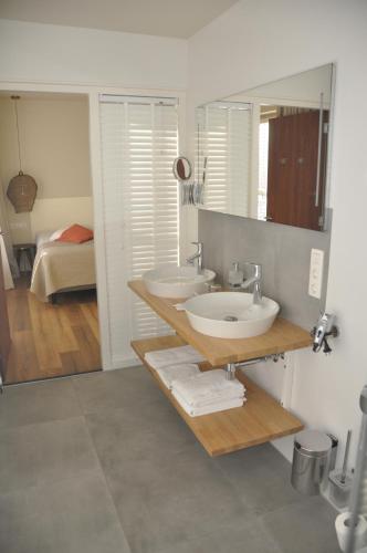 a bathroom with two sinks and a mirror at Hotel Sanders de Paauw in Sluis